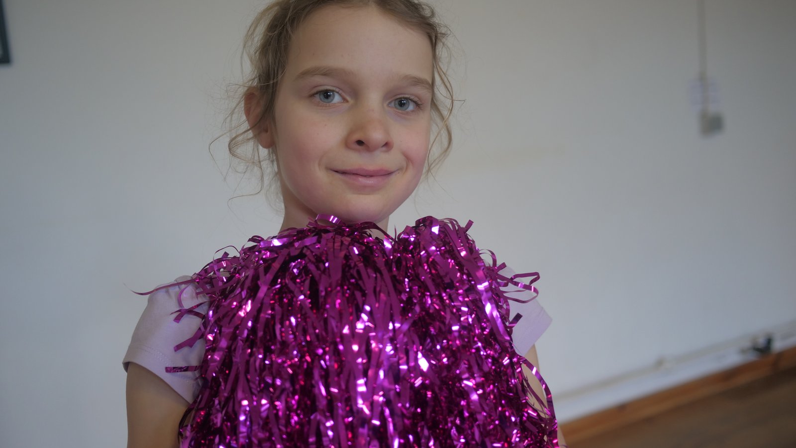 Jeune cheerleader avec pompon rose
