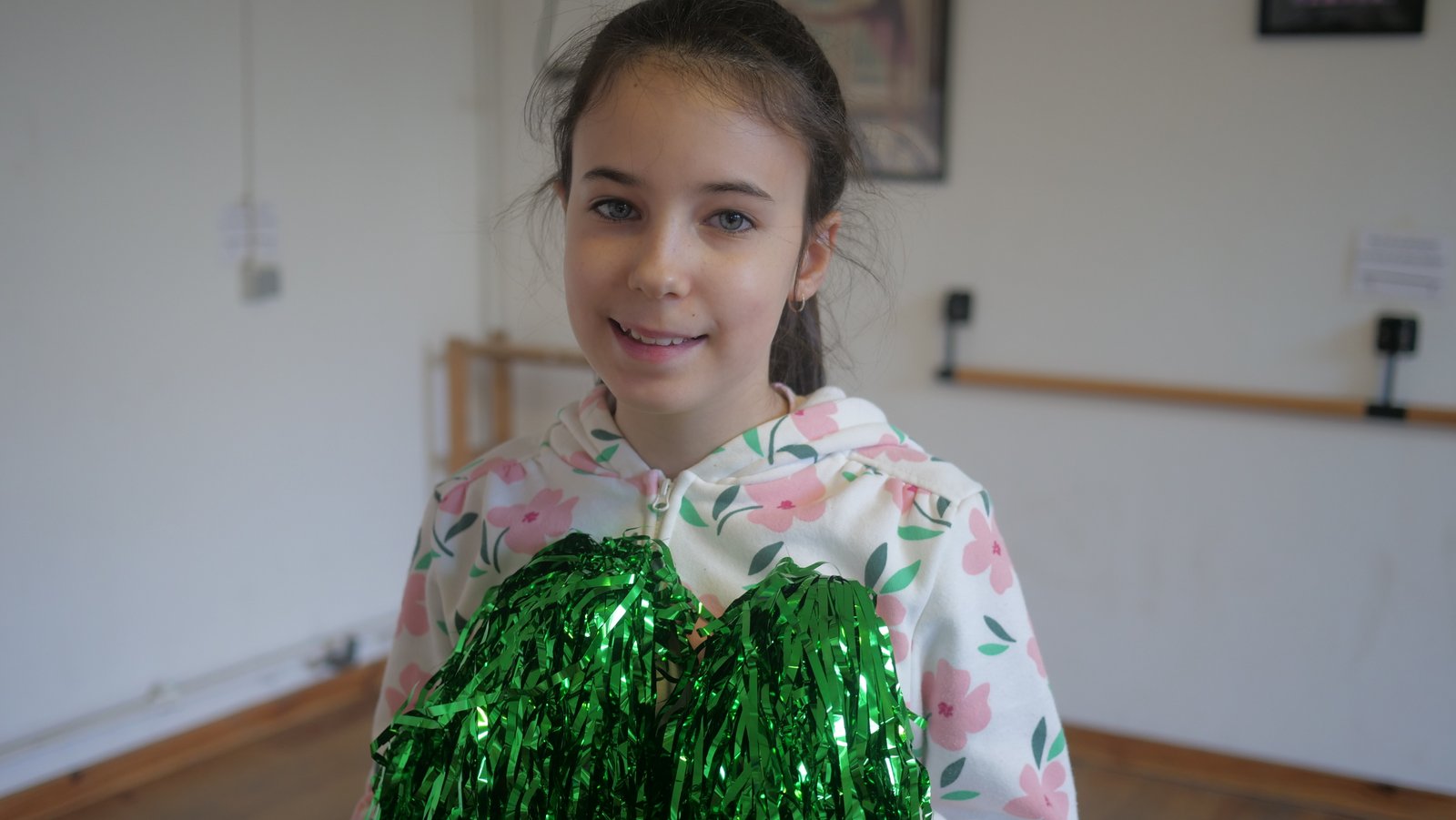 Cheerleader souriante avec pompon vert